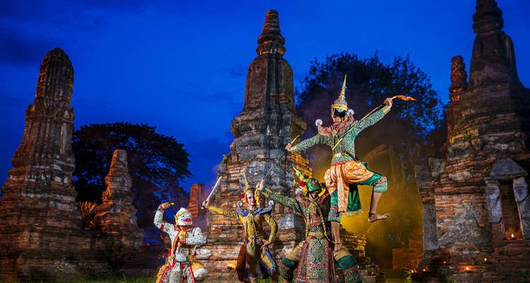 Spectacle de danse traditionnelle devant des ruines antiques la nuit.
