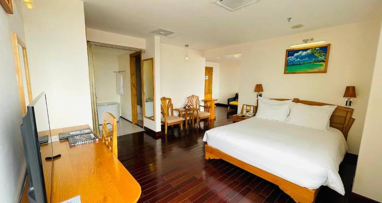 Spacious hotel room with hardwood floors.