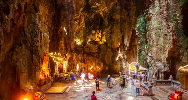 Dentro de una vibrante cueva de piedra caliza con muchos visitantes y santuario.
