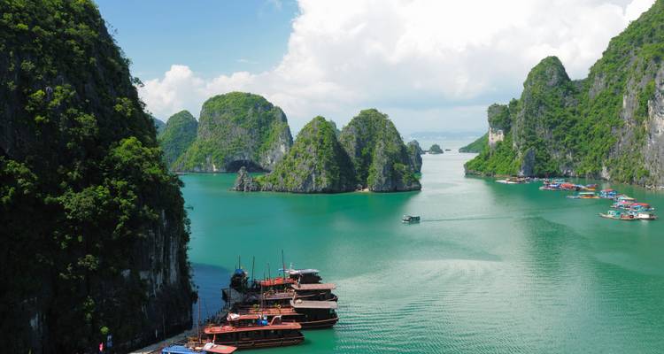 Scenic view of a bay with limestone karsts and wooden boats.