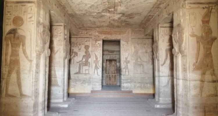 Tempelinterieur met oude Egyptische muurschilderingen en reliëfs.