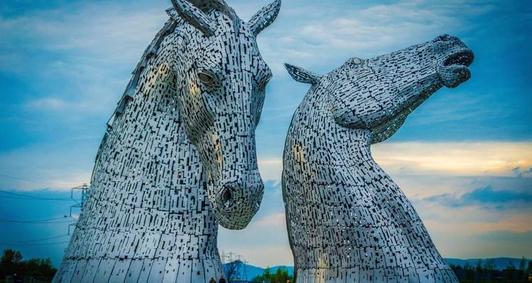 Las esculturas de los Kelpies al atardecer con un cielo dramático.