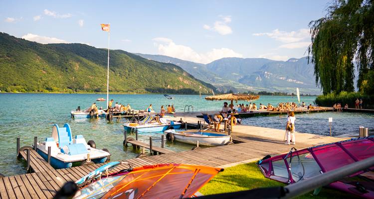 Lake scene with people, docks, and pedal boats.