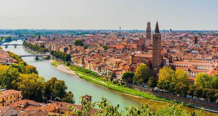 Panoramic view of a city with river and historical buildings.
