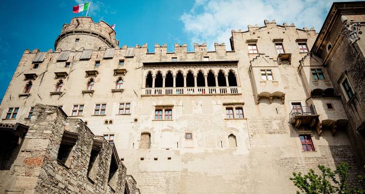Historic castle building with flags in a clear sky.