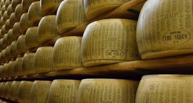 Gros plan de meules de parmesan empilées vieillissant dans une zone de stockage.