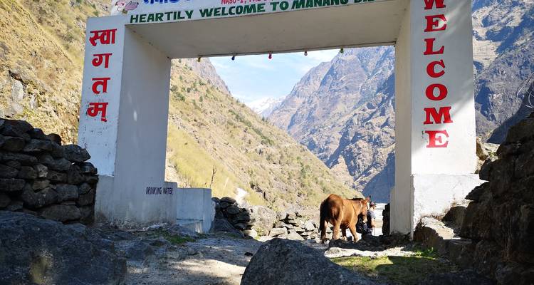 Entrada en arco al Valle de Manang con montañas al fondo.