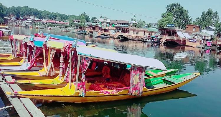 Bunte Boote auf einem ruhigen See unter einem hellen Himmel.