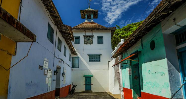 Callejón estrecho con edificios coloridos y cielo azul.