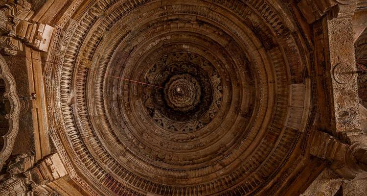Ornate concentric ceiling dome with intricate carvings viewed from directly below