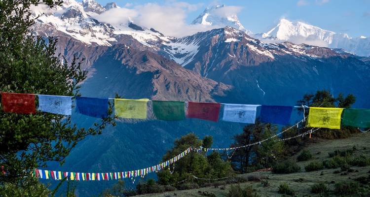 Bunte Gebetsfahnen vor schneebedeckter Bergkette