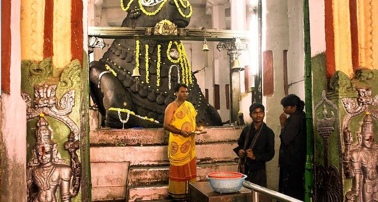Mensen die staan bij een standbeeld in een tempelomgeving.
