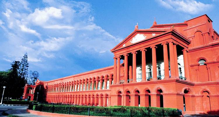 Bâtiment gouvernemental rouge avec colonnes, ciel dégagé.