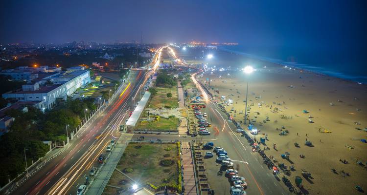 Costa urbana al atardecer con luces y tráfico.