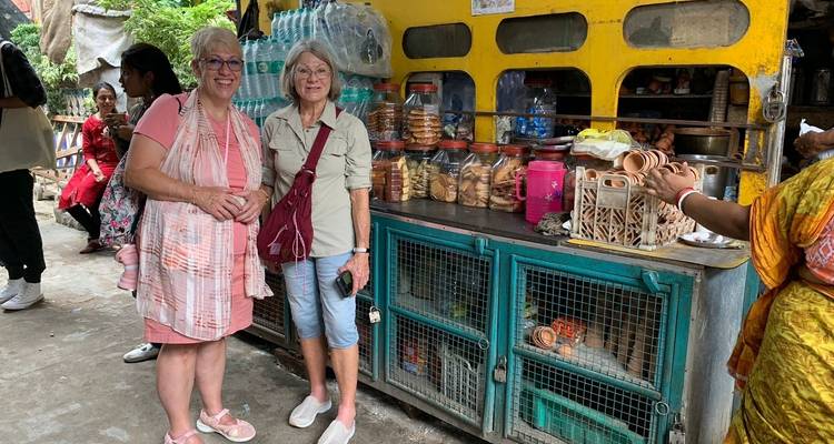 Dos mujeres frente a una exhibición de aperitivos empaquetados en un ambiente de mercado.