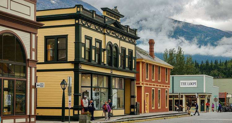 Heritage Gold Rush-era storefronts in Skagway against a backdrop of misty mountains.
