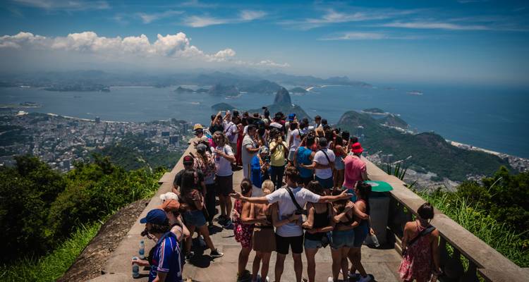 Multitud contemplando una vista panorámica de Río de Janeiro con el Pan de Azúcar.