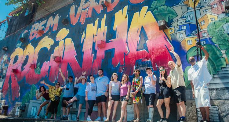 Grupo de personas posando frente a un mural colorido en Río de Janeiro.
