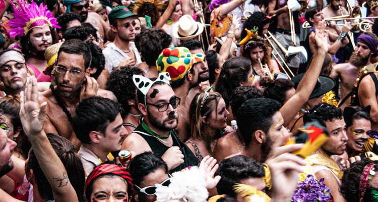 Foule en fête lors d'un Carnaval avec des costumes colorés.