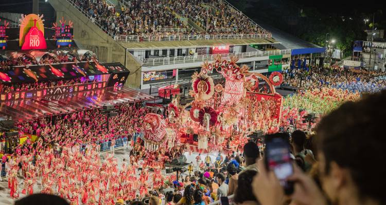 Gros plan d'un char de carnaval rouge élaboré se déplaçant à travers la Sambadrome bondée la nuit