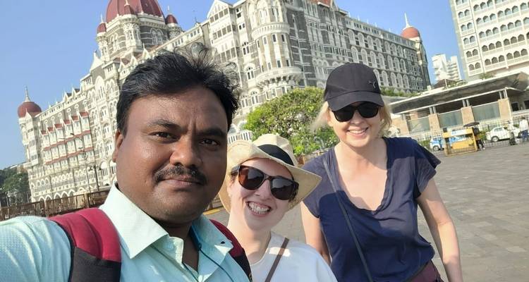 Drei Personen mit dem Taj Mahal Hotel im Hintergrund.