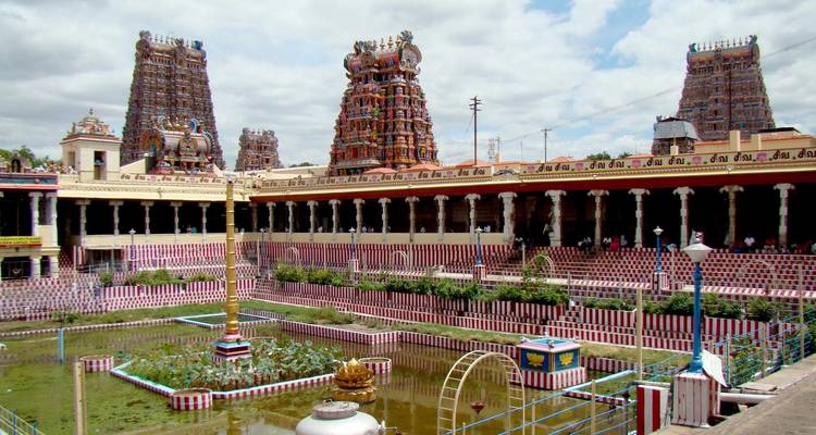 Groot tempelcomplex met kleurrijke gopurams en een heilige vijver.