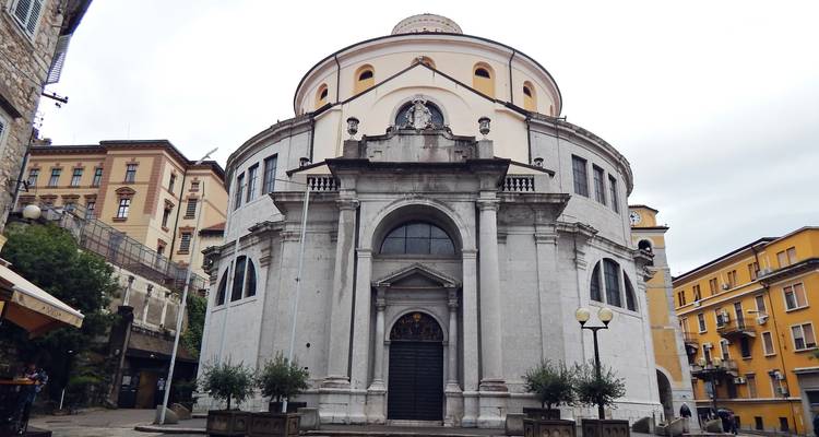 Iglesia barroca circular con una fachada ornamentada que domina una pequeña plaza croata.