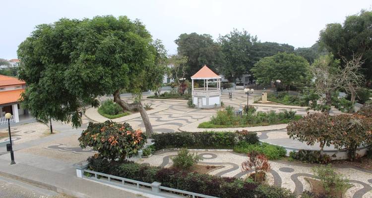 Gepflegter Gartenpark mit Bäumen, Gehwegen und einem zentralen Pavillon.