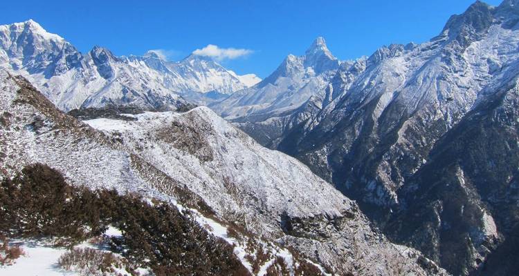 Snow-covered mountain range under a clear blue sky.