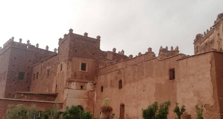 Oud Marokkaans gebouw met bewolkte lucht erboven.