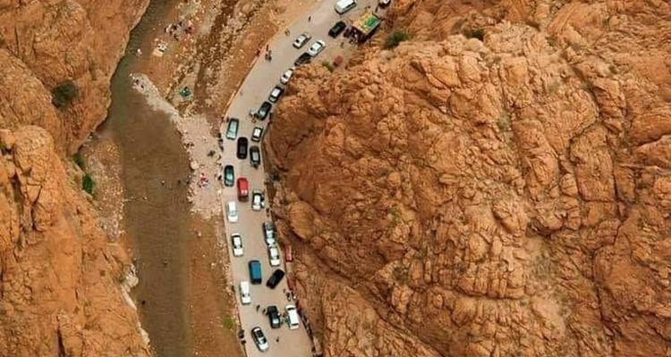 A canyon with a line of cars along a narrow road.