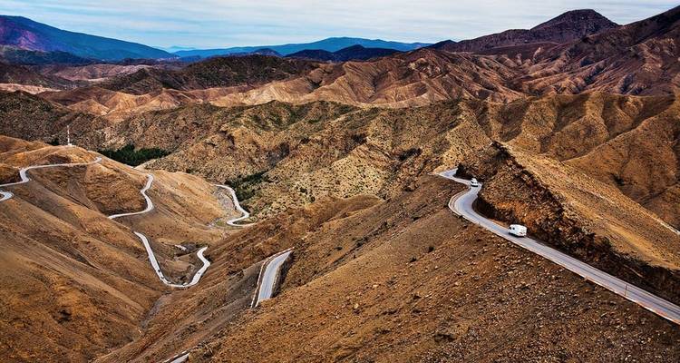 Carretera serpenteante a través de un paisaje montañoso rocoso.