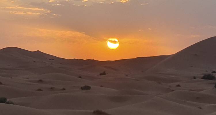 Atardecer sobre las dunas de arena en el desierto.