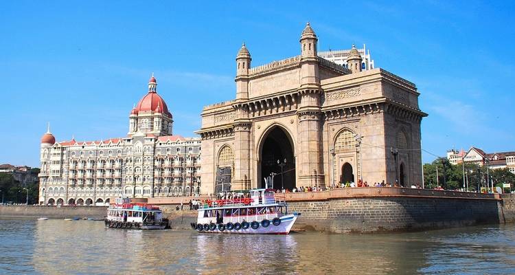 Boote und das ikonische Gateway of India mit dem Taj Mahal Palace Hotel.