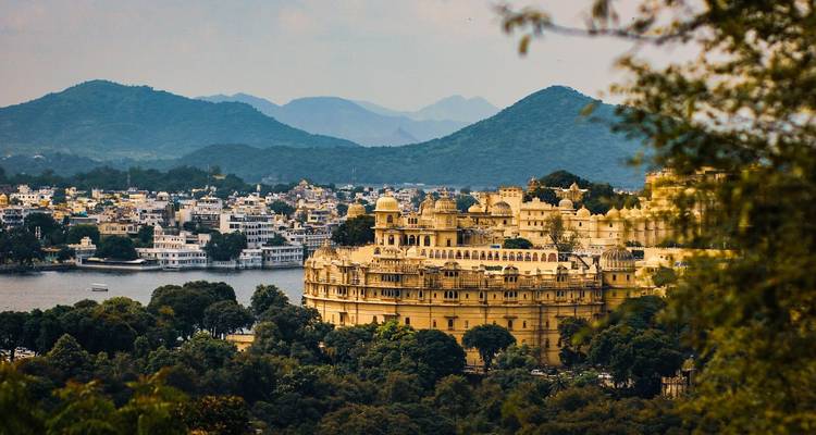 Een schilderachtig uitzicht op een stad met een groot paleis en bergen.