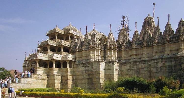 Een gedetailleerde Jain-tempel met sierlijke bewerkingen en bezoekers.