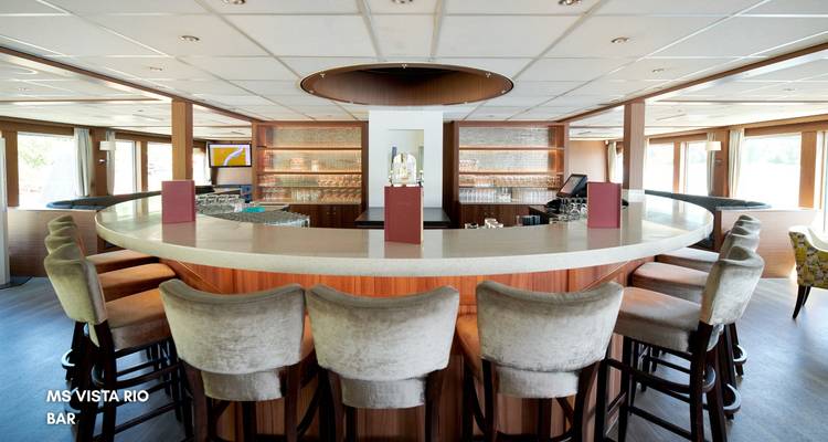 Bar area on a ship with a large counter and stools, text overlay present.