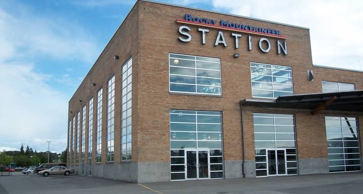 Estación de tren Rocky Mountaineer, edificio de ladrillo con ventanas grandes.