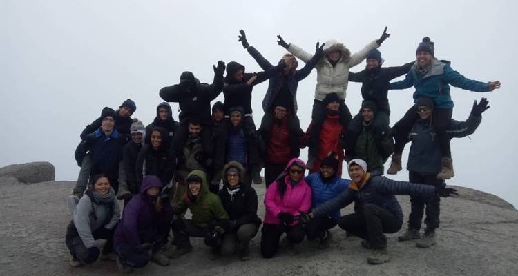 Eine Gruppe von Menschen, die für ein Foto posieren, während sie auf einer Bergwanderung sind.