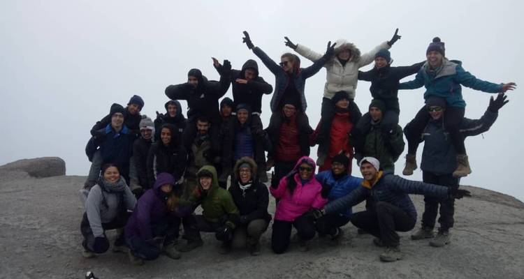 Eine Gruppe von Menschen auf dem Gipfel, die für ein Foto posieren.