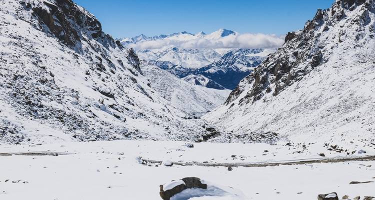 Schneebedecktes Bergtal unter einem klaren blauen Himmel.