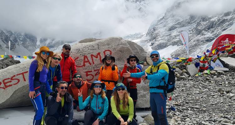 Gruppe von Wanderern, die ein Foto mit dem Everest Base Camp Felsen macht.