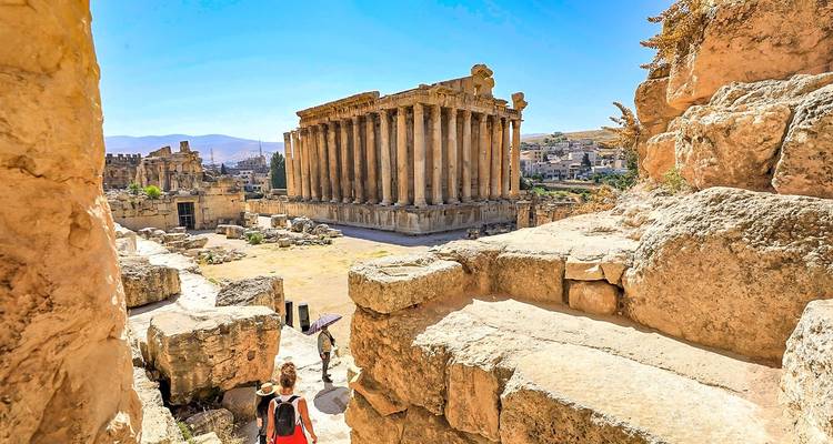 Turistas explorando ruinas antiguas con grandes estructuras de piedra.