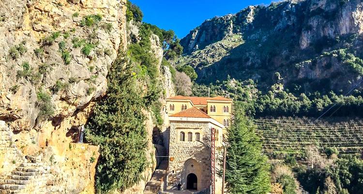 Antiguo monasterio de piedra enclavado en exuberantes montañas verdes.