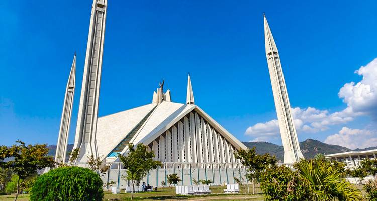 Mezquita moderna con minaretes altos contra un cielo azul.