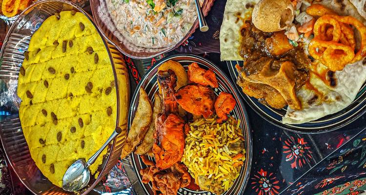 Platos tradicionales pakistaníes con varios alimentos coloridos en platos.