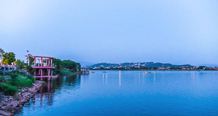 Lago tranquilo con montañas distantes y una atmósfera serena.