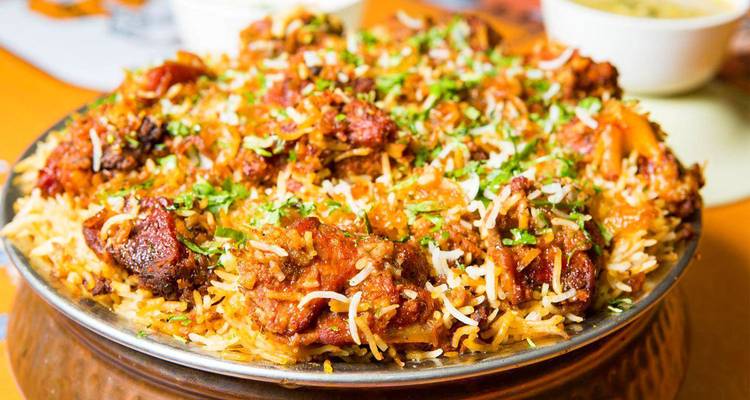 Un plato de biryani de aspecto delicioso adornado con hierbas.