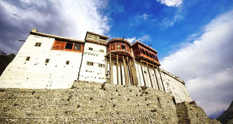 Un fuerte histórico construido en una colina rocosa con un cielo dramático.