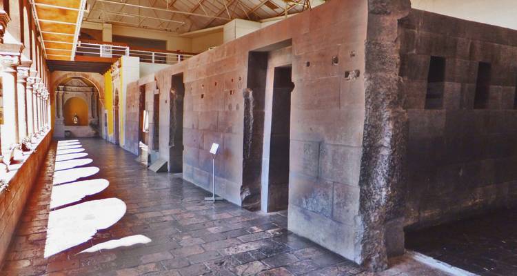 Interior walkway with ancient stone walls and window arches.